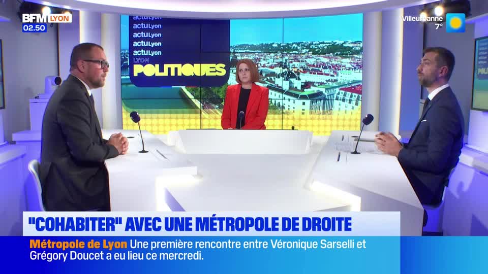 The BFM Lyon broadcast is discussing the Métropole de Lyon. A woman in a red jacket sits between two men in suits at a white desk.