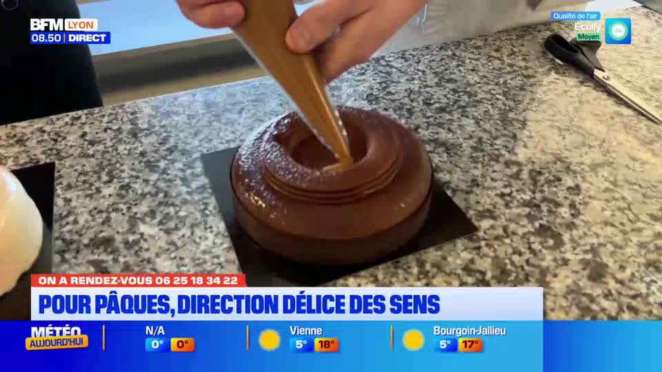 A pastry chef is piping a caramel filling into a chocolate cake. This is part of a segment for BFM Lyon about Easter treats.
