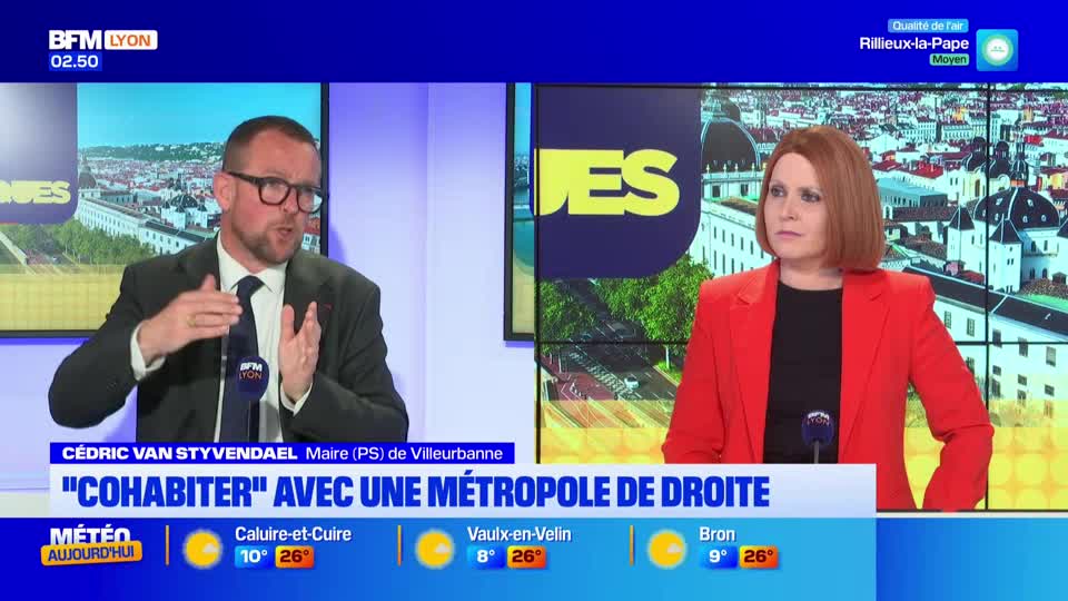 A man in a suit and glasses gestures with his hands, speaking animatedly. Beside him, a woman in a bright red blazer listens intently. A man in a suit and glasses gestures with his hands, speaking animatedly. Beside him, a woman in a bright red blazer listens intently.