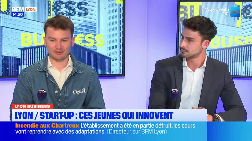 Two men sit at a desk, one in a denim jacket, the other in a suit, speaking on what appears to be a BFM Lyon broadcast. The screen behind them displays the words "BUSINESS" in large yellow letters. Two men sit at a desk, one in a denim jacket, the other in a suit, speaking on what appears to be a BFM Lyon broadcast. The screen behind them displays the words "BUSINESS" in large yellow letters.