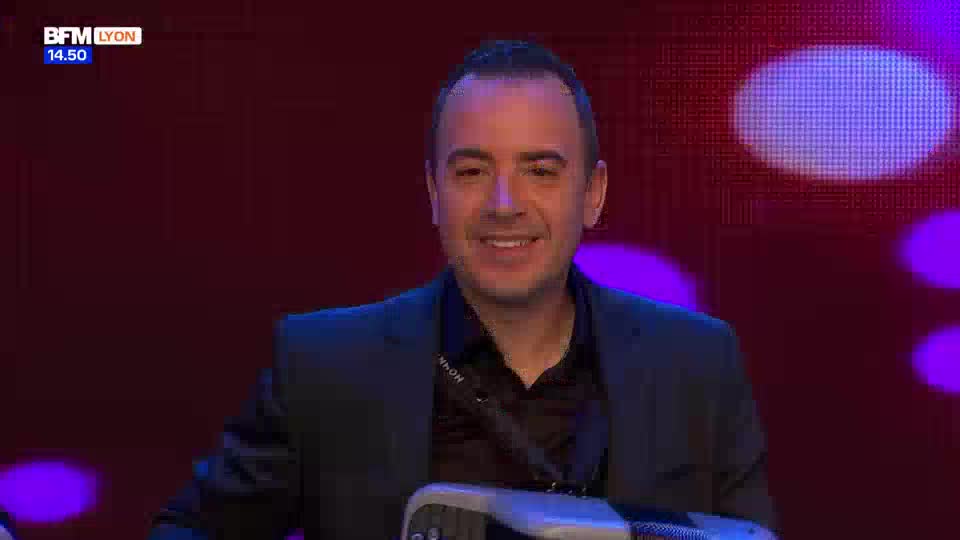 A man in a dark suit smiles, holding an accordion. The BFM Lyon logo appears in the corner.