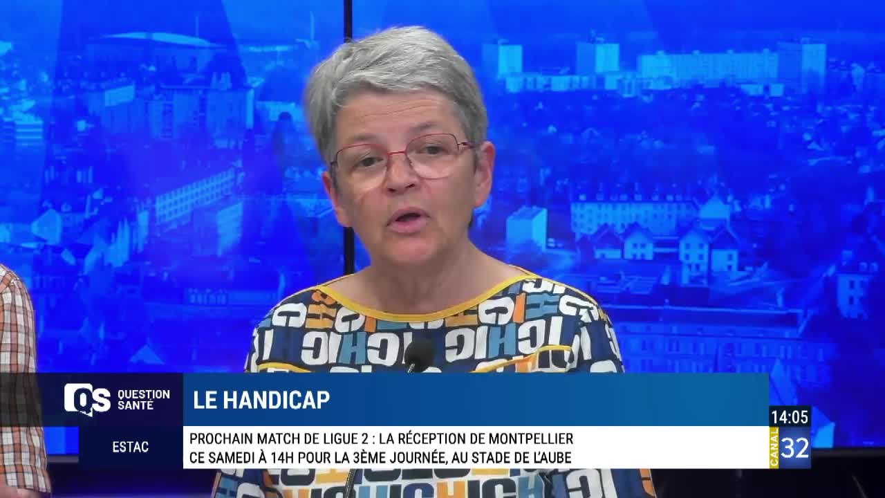 A woman with short gray hair and glasses speaks directly to the camera on a Canal 32 broadcast from France. The screen behind her shows a blue cityscape, and the lower third displays text about a Ligue 2 match.
