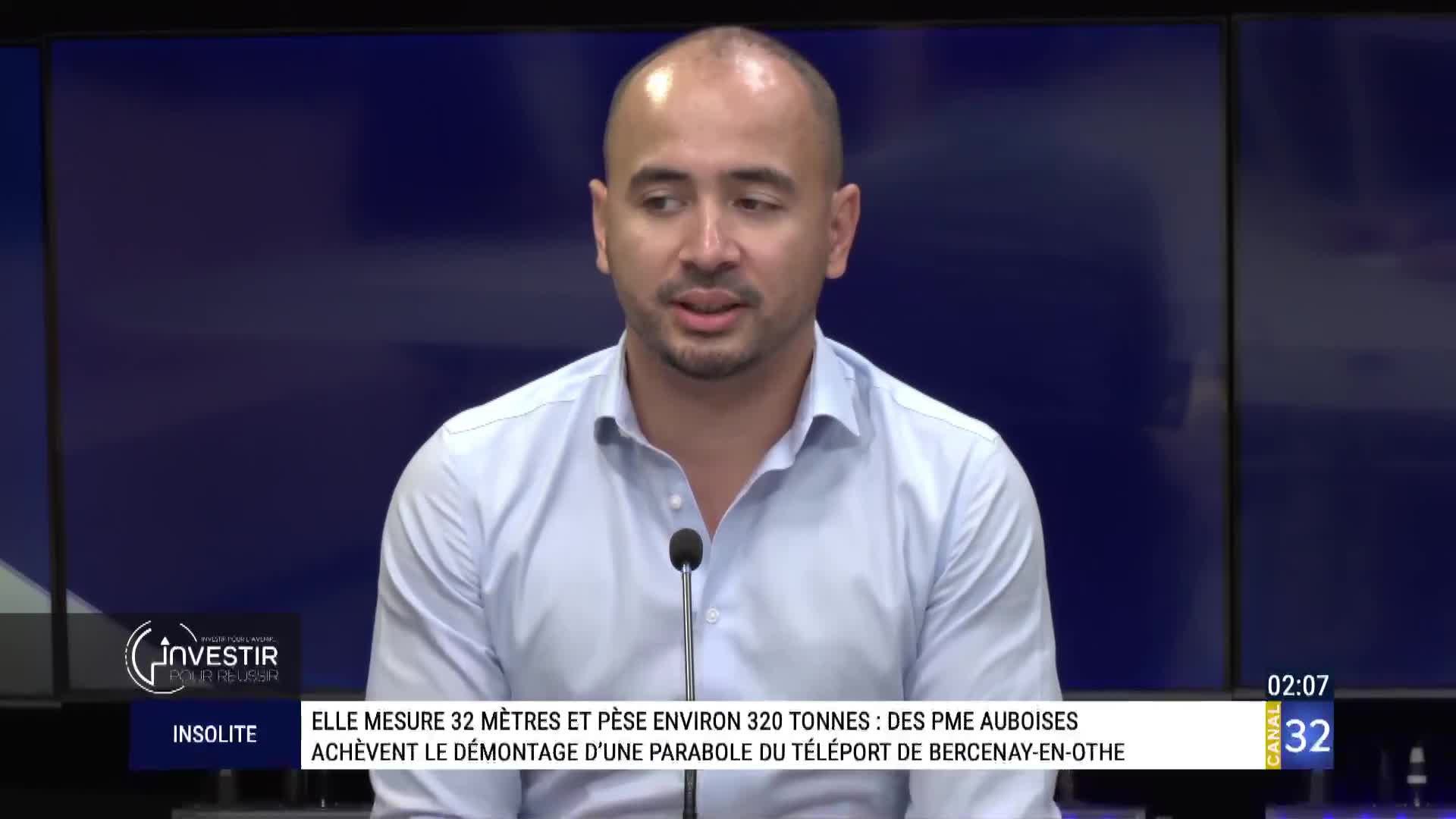 A man in a light blue shirt speaks into a microphone, likely on Canal 32 in France. The lower third of the screen displays text about the dismantling of a telecommunications antenna.

