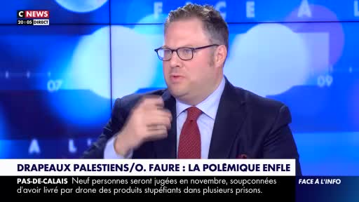 A man in a suit and glasses gestures with his right hand, speaking on a CNews broadcast. The lower third of the screen displays a headline about Palestinian flags and a story about drug deliveries by drone in the Pas-de-Calais region.
