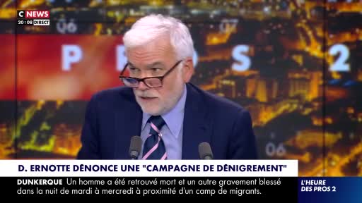 On the CNews set, a man in a suit and tie, wearing glasses, is speaking into a microphone. The headline at the bottom of the screen mentions a "campaign of denigration" and a death near a migrant camp in Dunkerque, France.
