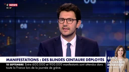 A man in a suit and tie, wearing glasses, is speaking directly to the camera on CNews. Text on the screen mentions a strike in France and the deployment of armored vehicles.
