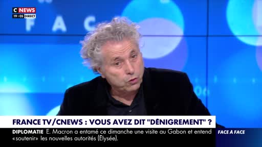 A man with gray, curly hair is speaking, his mouth open. The bottom of the screen displays "France TV/CNews" and a headline in French, with a news ticker about a visit to Gabon.

