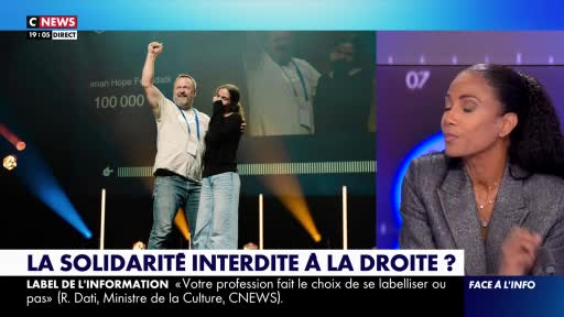 On a CNews broadcast, a man with a raised fist celebrates a milestone, while a woman stands beside him. Across the studio, a presenter looks on, as the screen displays a question about solidarity.
