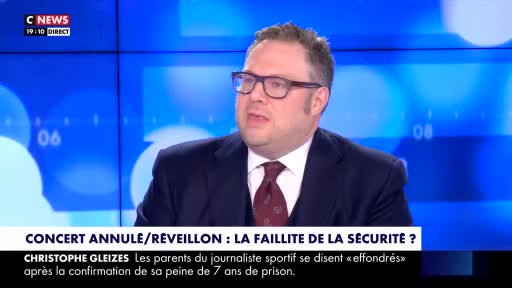A man in a suit and glasses speaks earnestly on a CNews broadcast from France. Below him, the screen displays a headline about security failures and a news story about a sports journalist.
