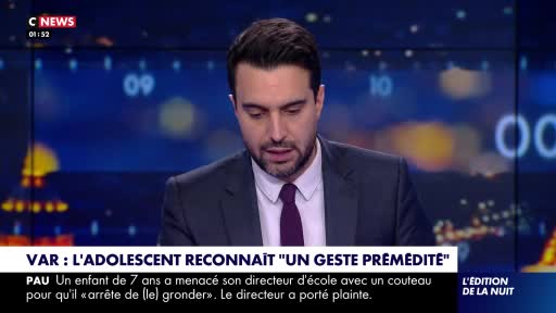 A man in a suit and tie looks down, his gaze fixed on something below the frame. Behind him, the CNews logo and a digital display show a nighttime cityscape.