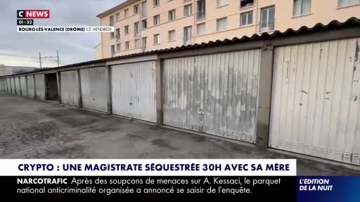 A row of weathered garage doors stretches out before me, their metal surfaces stained and peeling. Behind them, a pale, apartment building rises against a muted sky.