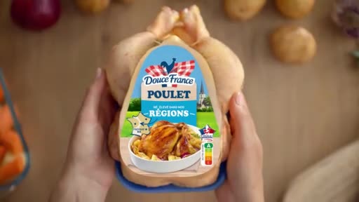 Someone is holding a whole, uncooked chicken. The label on the chicken advertises "Douce France Poulet" and shows a picture of a roasted chicken with potatoes.
