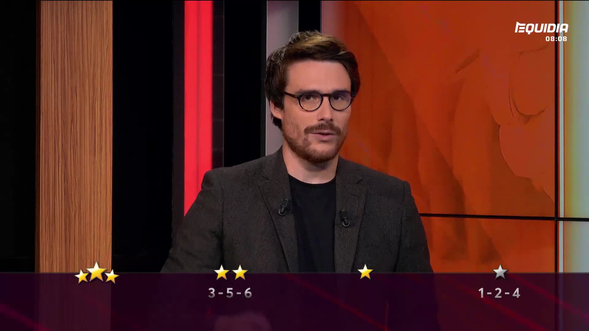 A man in glasses, wearing a blazer, speaks directly to the camera. The Equidia logo is visible, and a graphic displays the race results.
