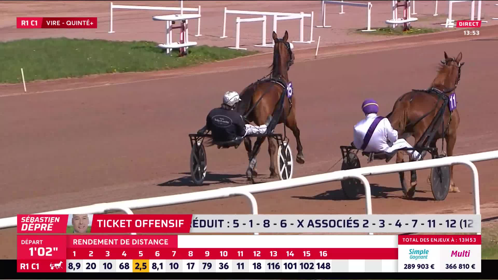 Two trotting horses pull their sulkies down the dirt track. The horse on the right, number 11, is slightly ahead of the one on the left, number 15.
