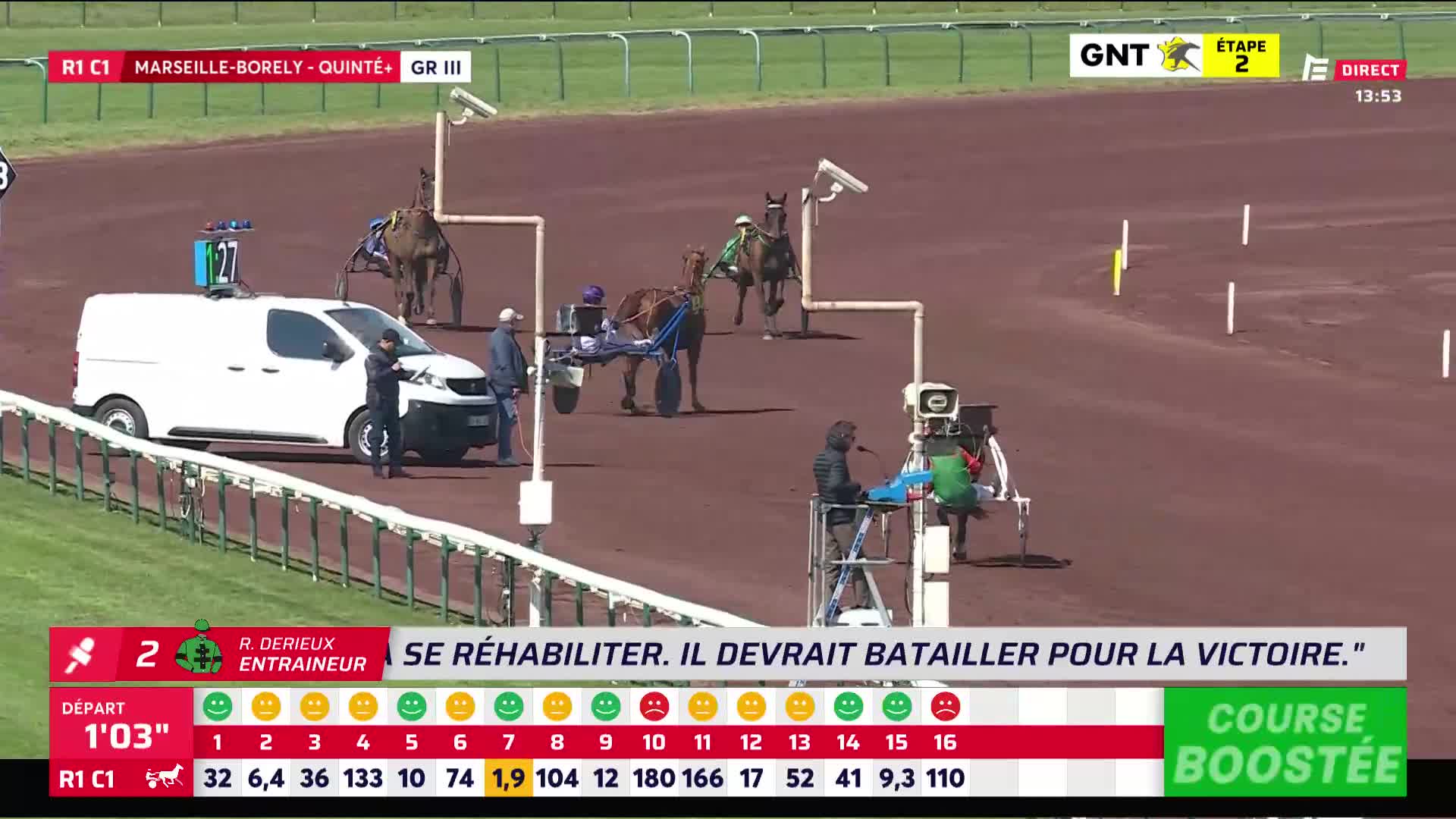 A horse pulling a sulky moves past a white van on the track. Another horse and sulky are further ahead, nearing a camera post.