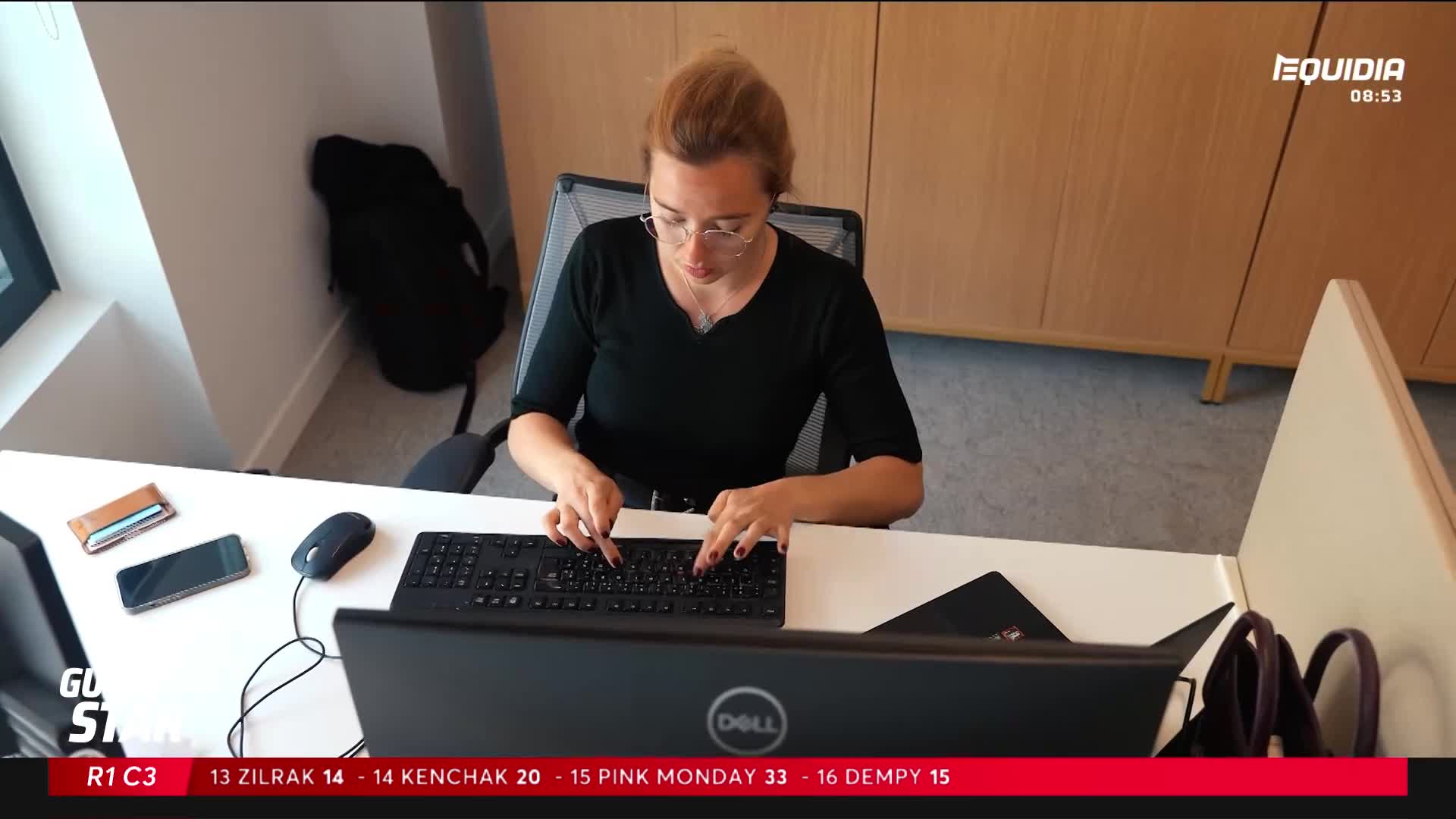 Fingers fly across the keyboard as the woman works, her focus sharp. A phone and wallet sit neatly on the desk beside her. Fingers fly across the keyboard as the woman works, her focus sharp. A phone and wallet sit neatly on the desk beside her.