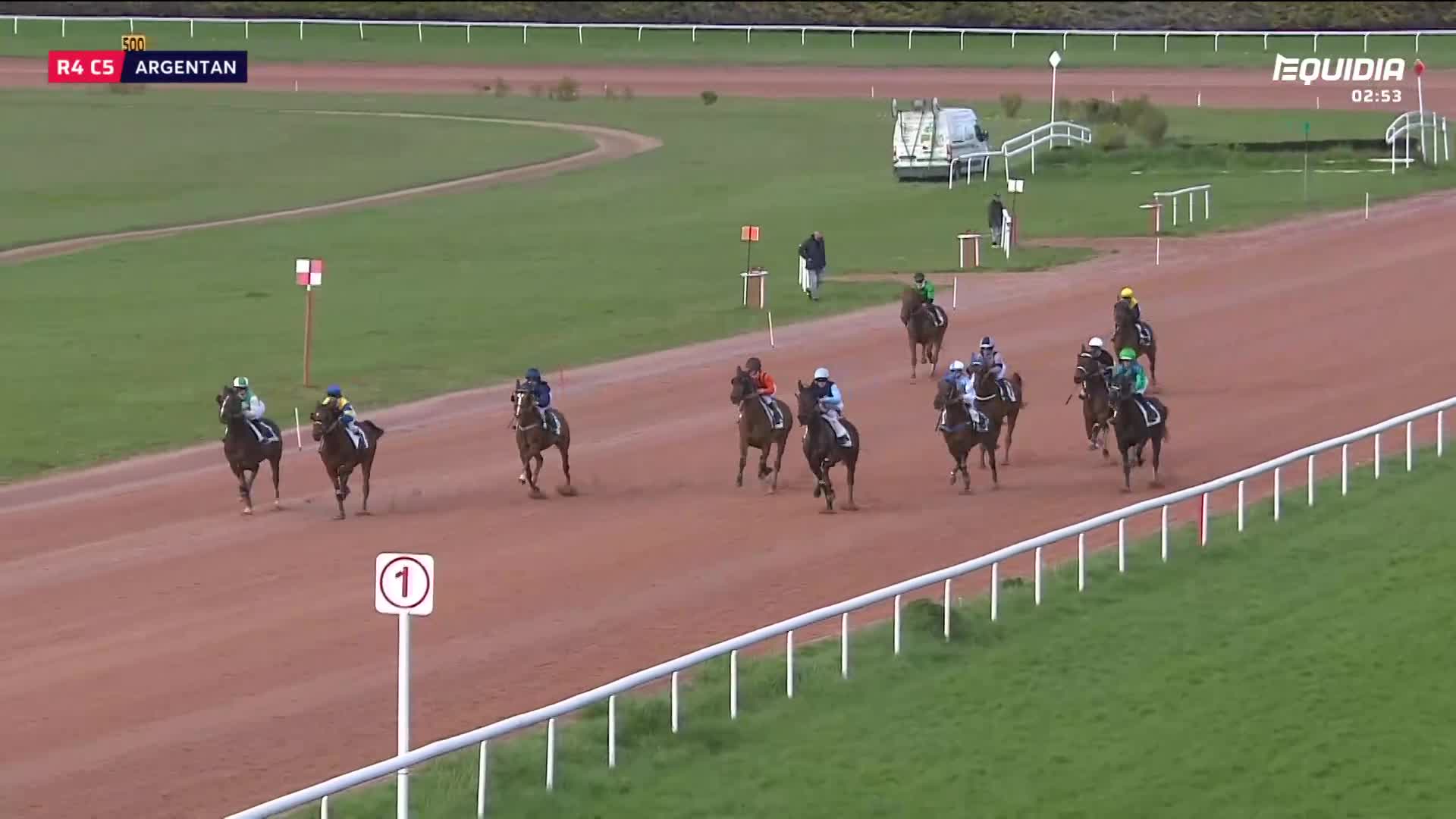 The horses are thundering down the track, their riders hunched low. A tight pack of racers is approaching the finish line, each jockey pushing their mount. The horses are thundering down the track, their riders hunched low. A tight pack of racers is approaching the finish line, each jockey pushing their mount.
