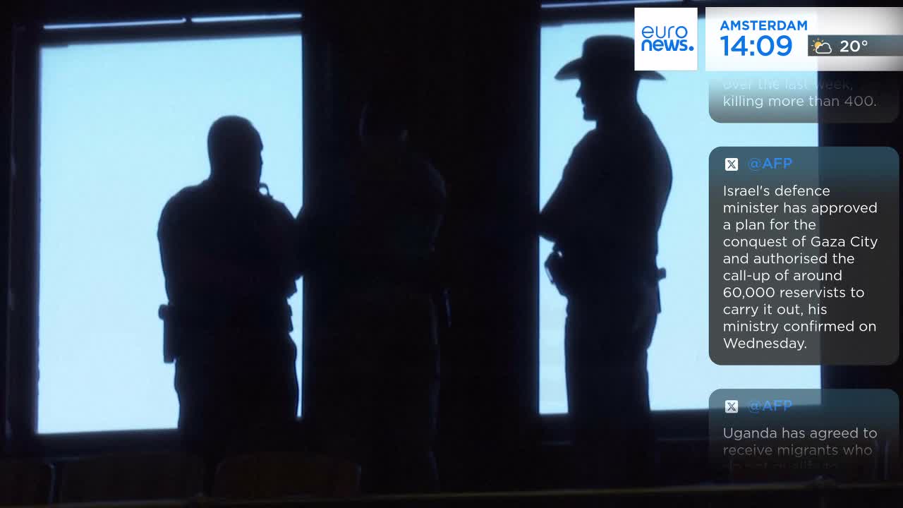 Three figures stand in silhouette against a bright window, one wearing a cowboy hat. The Euronews English feed at the top of the screen shows the time and weather in Amsterdam.
