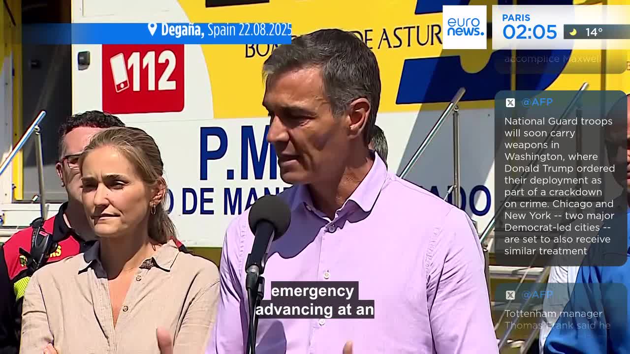 A man in a pink shirt speaks into a microphone, his words subtitled on the screen. Behind him, a woman stands, her expression serious, as the Euronews English broadcast unfolds.
