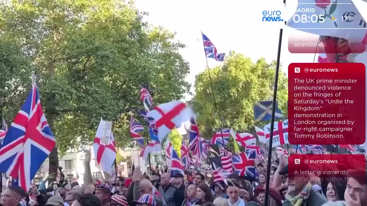Union Jacks and St. George's Cross flags are held aloft, waving above a crowd of people. Euronews reports on a demonstration in London, with the UK prime minister denouncing violence.
