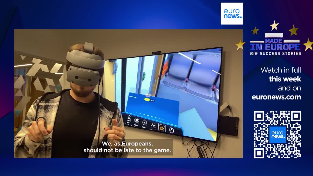 A man wearing a VR headset is interacting with a virtual train carriage displayed on a large screen. The screen shows a digital representation of seats and windows, with a menu bar at the bottom. A man wearing a VR headset is interacting with a virtual train carriage displayed on a large screen. The screen shows a digital representation of seats and windows, with a menu bar at the bottom.