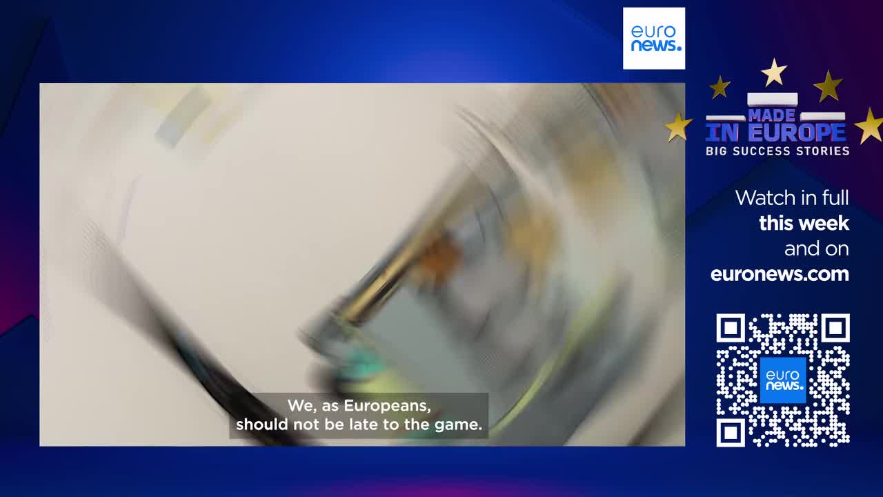 A metallic object spins rapidly, its surface a streak of silver and green. The text on screen, in English, states, "We, as Europeans, should not be late to the game." A metallic object spins rapidly, its surface a streak of silver and green. The text on screen, in English, states, "We, as Europeans, should not be late to the game."