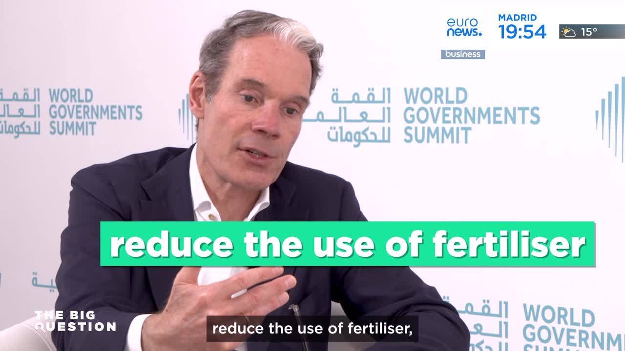 A man in a dark suit speaks with his hands animated, while a bright green banner across the screen reads "reduce the use of fertiliser." The Euronews logo and "MADRID 19:54" appear in the upper right corner, indicating a broadcast from Spain. A man in a dark suit speaks with his hands animated, while a bright green banner across the screen reads "reduce the use of fertiliser." The Euronews logo and "MADRID 19:54" appear in the upper right corner, indicating a broadcast from Spain.