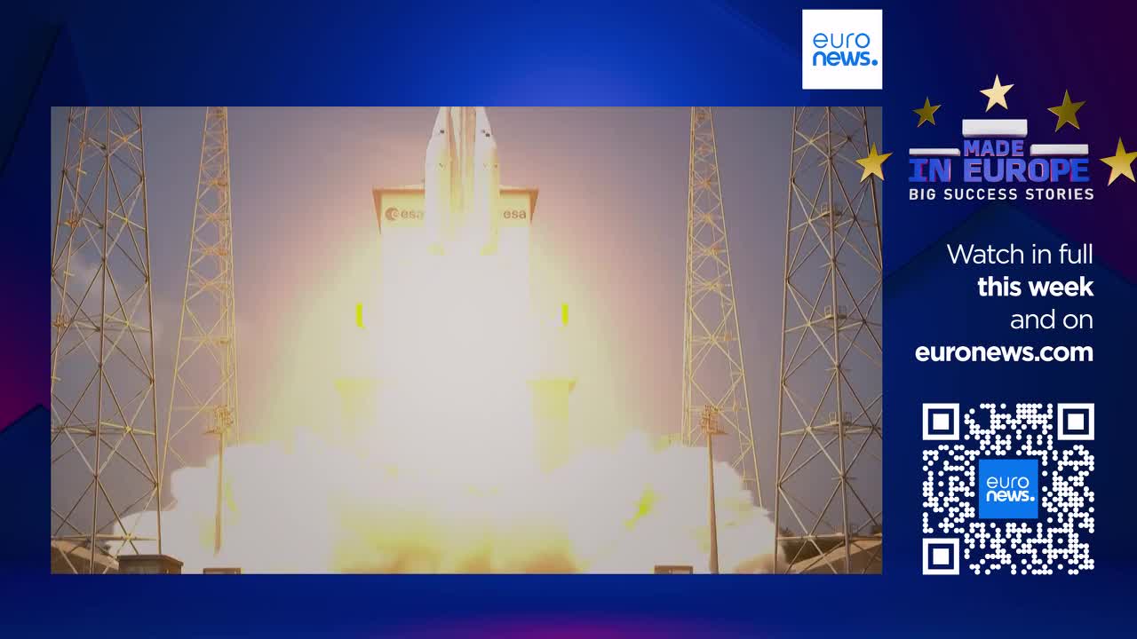 A rocket blasts off from Kourou, French Guiana, engulfing the launchpad in a brilliant white and orange inferno. The European Space Agency's vessel ascends rapidly, leaving behind a thick plume of smoke against the bright sky.