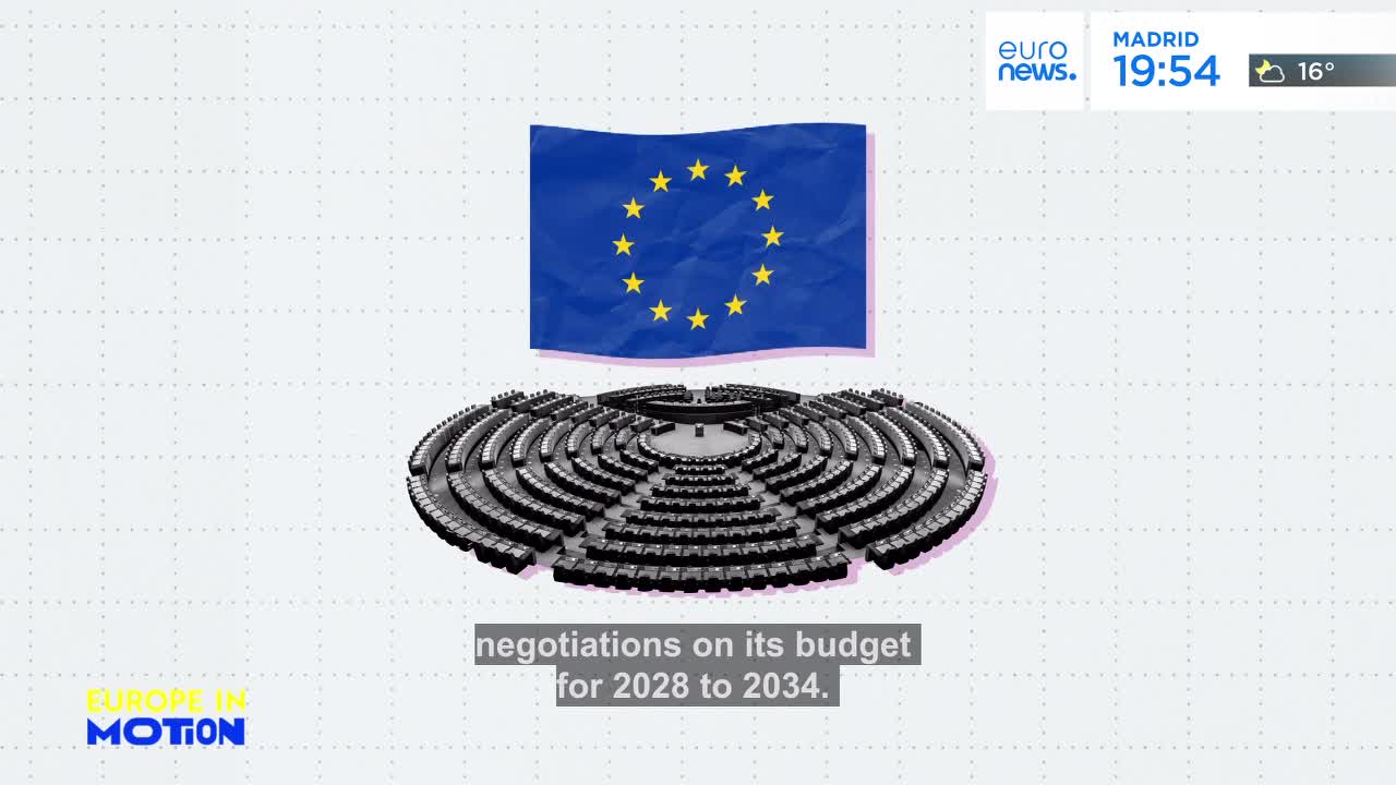 The European Union flag hangs above a circular chamber of tiered seating. Negotiations on its budget for 2028 to 2034 are underway.