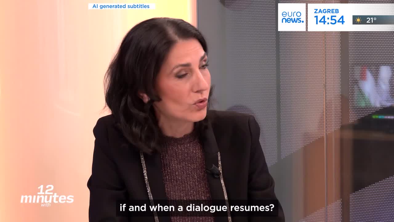 A woman with dark hair speaks, her expression earnest. A graphic on the screen behind her indicates it's 14:54 in Zagreb.