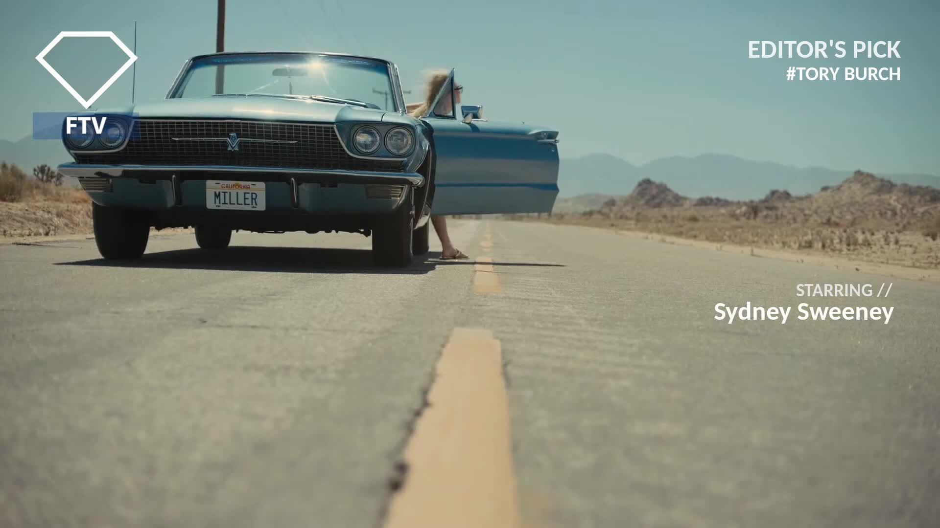 A vintage blue convertible sits on a sun-baked road, its door open. A woman in a sundress steps out, her feet touching the asphalt.

