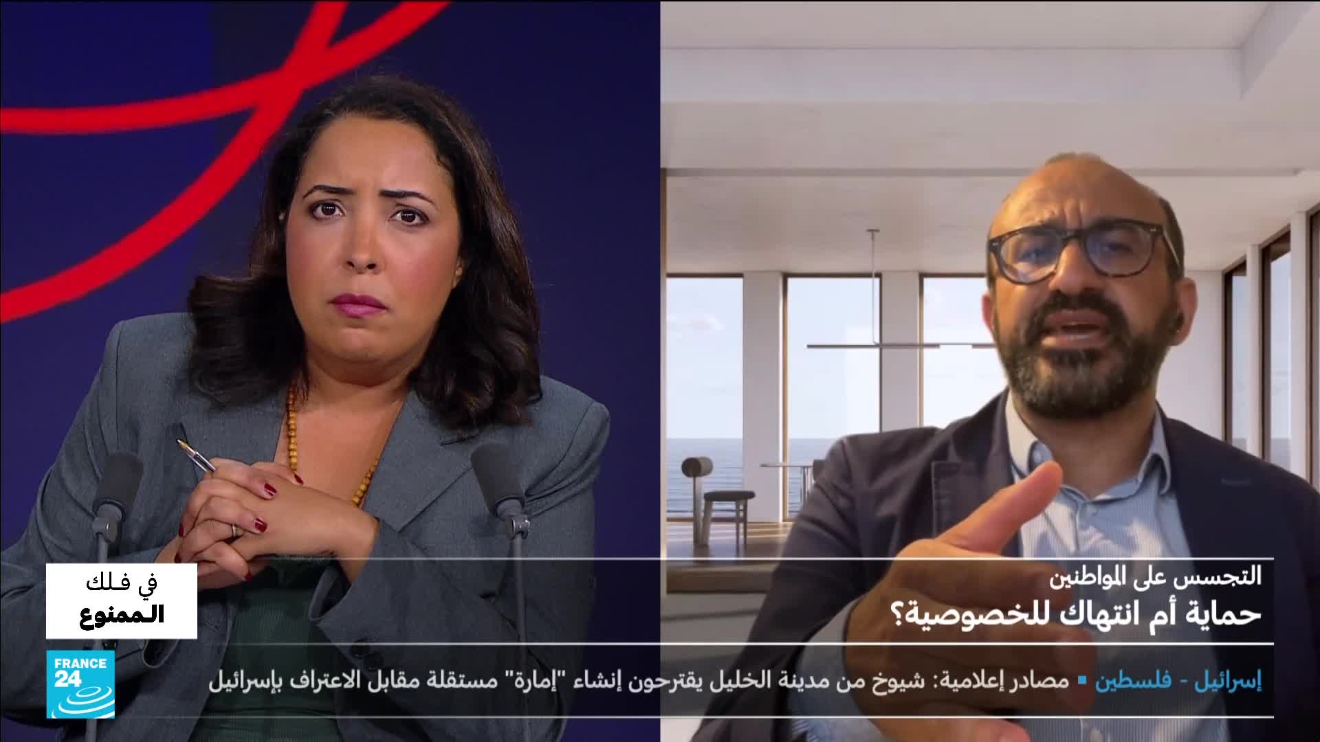 On France 24, a woman in a grey suit looks intently at the camera, a pen in her hand. Across the screen, a man gestures emphatically as he speaks, with a modern apartment visible behind him.
