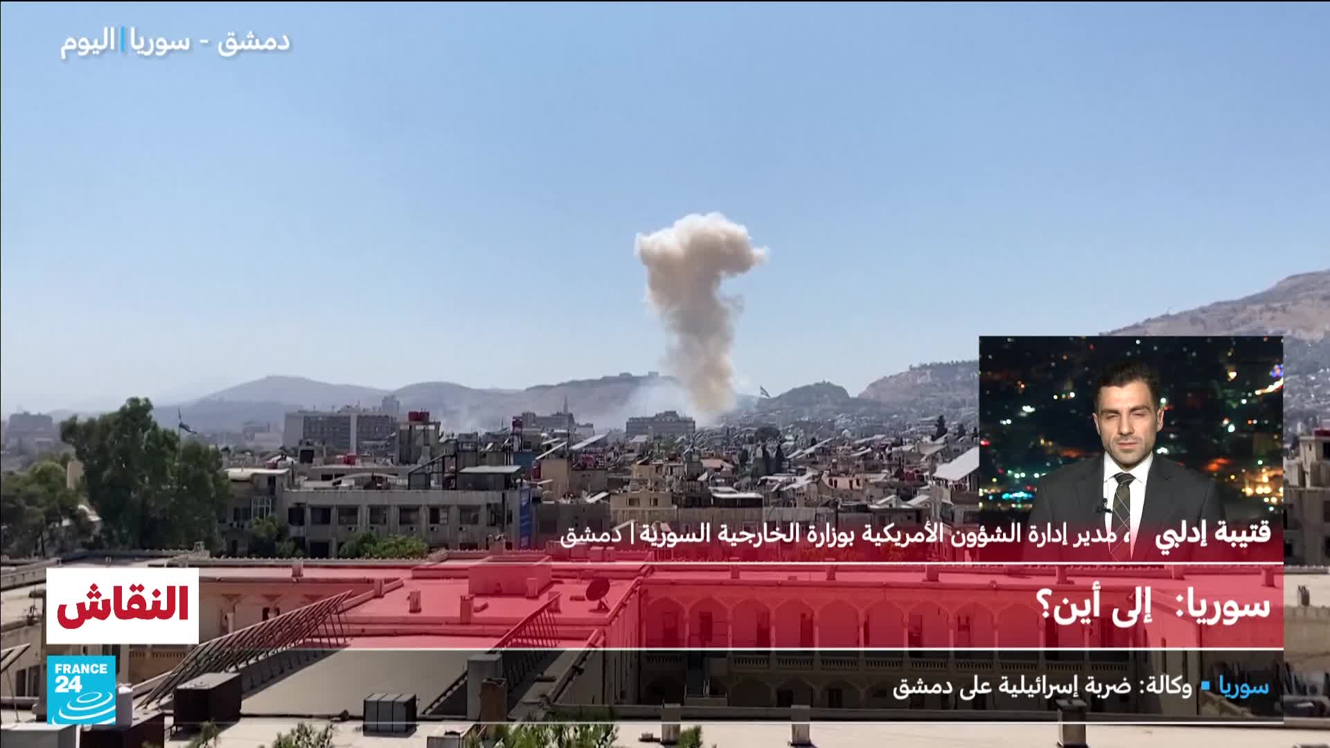 A large plume of smoke billows over the city, visible from the France 24 broadcast.  A man in a suit, likely a guest on the show, appears in the corner as the coverage focuses on the aftermath of an apparent strike in Damascus.
