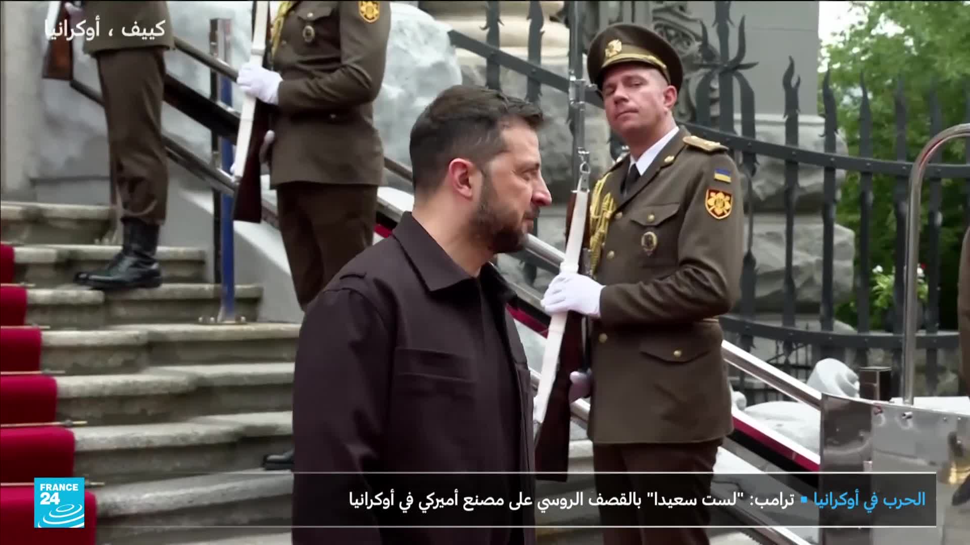 Zelensky, flanked by uniformed guards, walks down a set of stone steps covered with a red carpet. The France 24 logo is visible in the corner, and the headline mentions a statement by Trump about the war in Ukraine.

