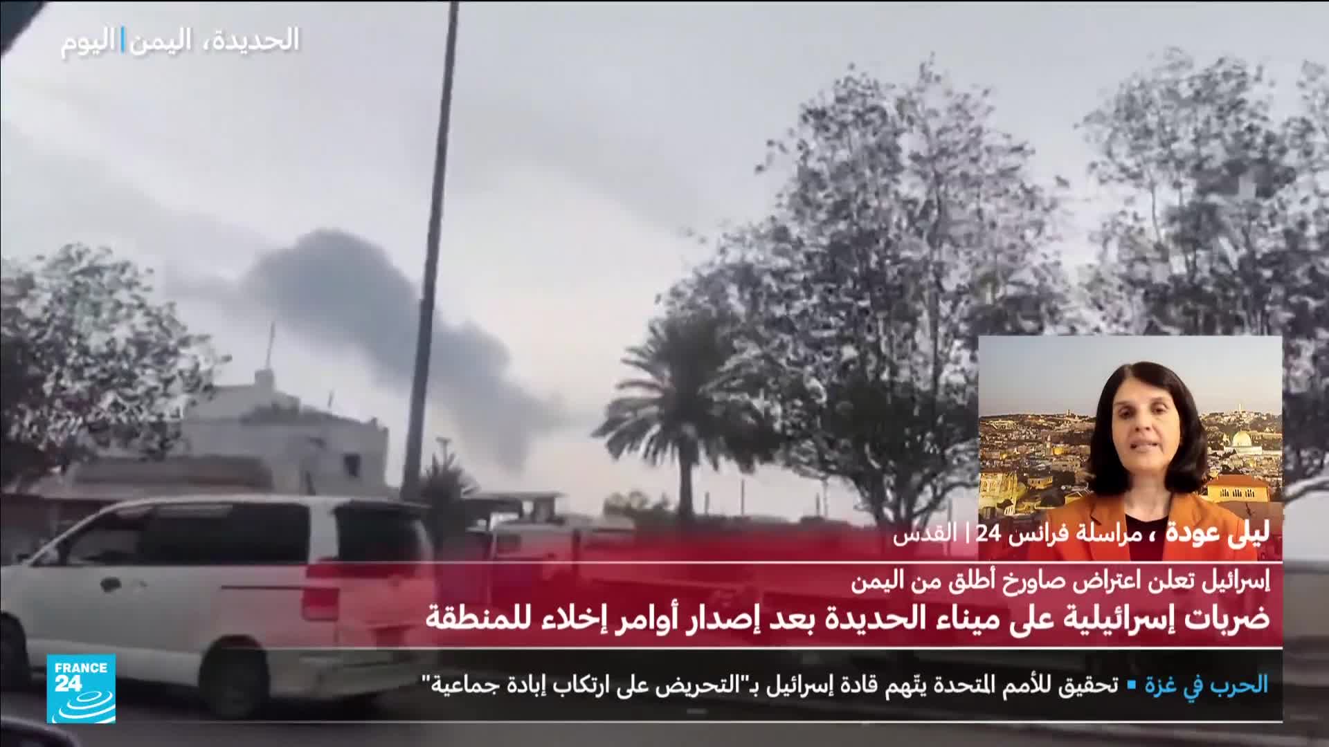 A plume of dark smoke billows above buildings, likely the result of an explosion. A France 24 correspondent in Jerusalem is reporting on the situation in Yemen, which is also the location of the news banner.
