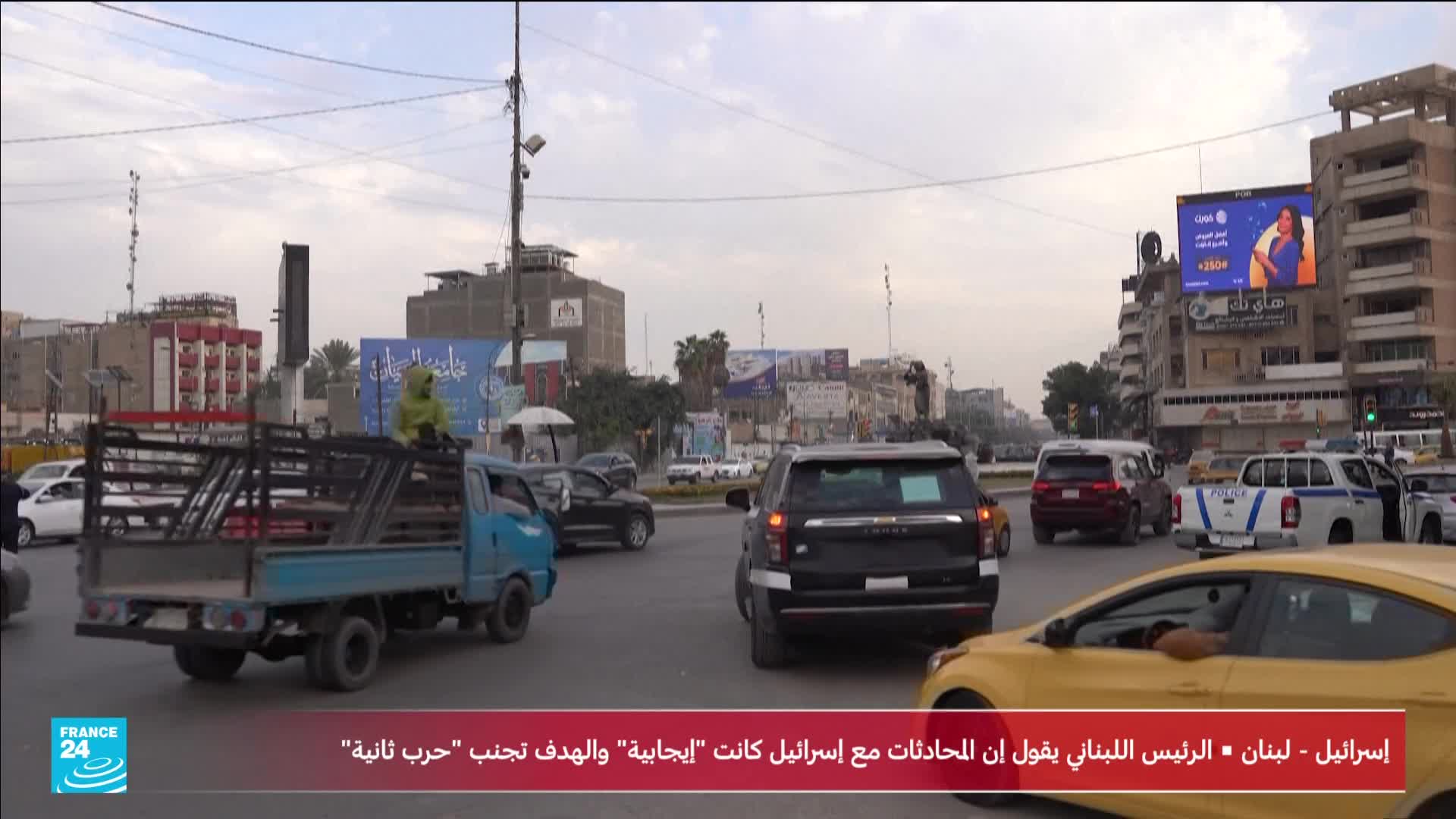 Traffic flows through a city intersection, with a small blue truck carrying a passenger in a yellow hooded jacket. A France 24 graphic appears at the bottom of the screen, reporting on discussions between Israel and Lebanon.
Traffic flows through a city intersection, with a small blue truck carrying a passenger in a yellow hooded jacket. A France 24 graphic appears at the bottom of the screen, reporting on discussions between Israel and Lebanon.