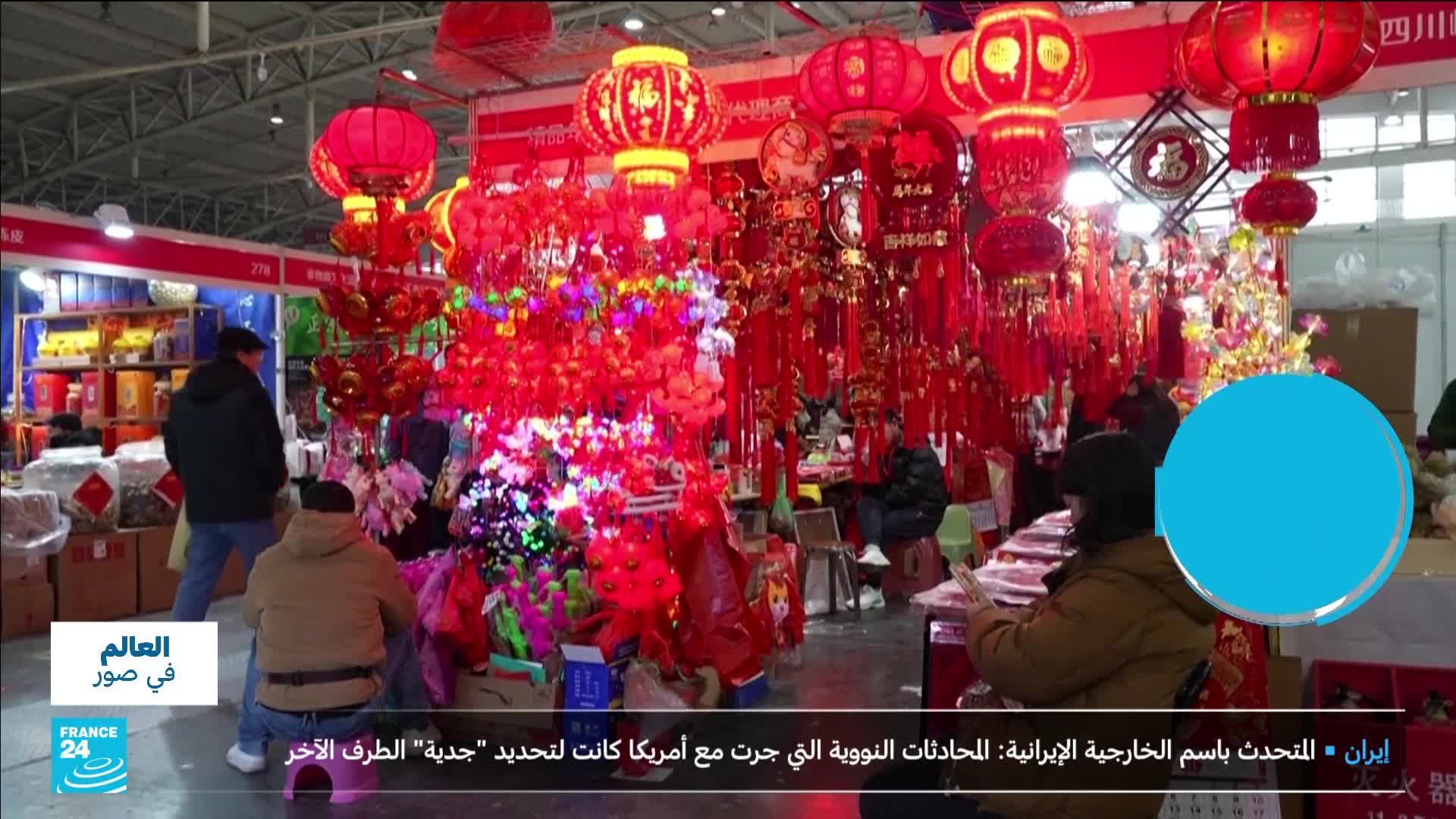 A stall overflows with bright red lanterns and festive decorations. People browse the goods, their faces illuminated by the vibrant display.