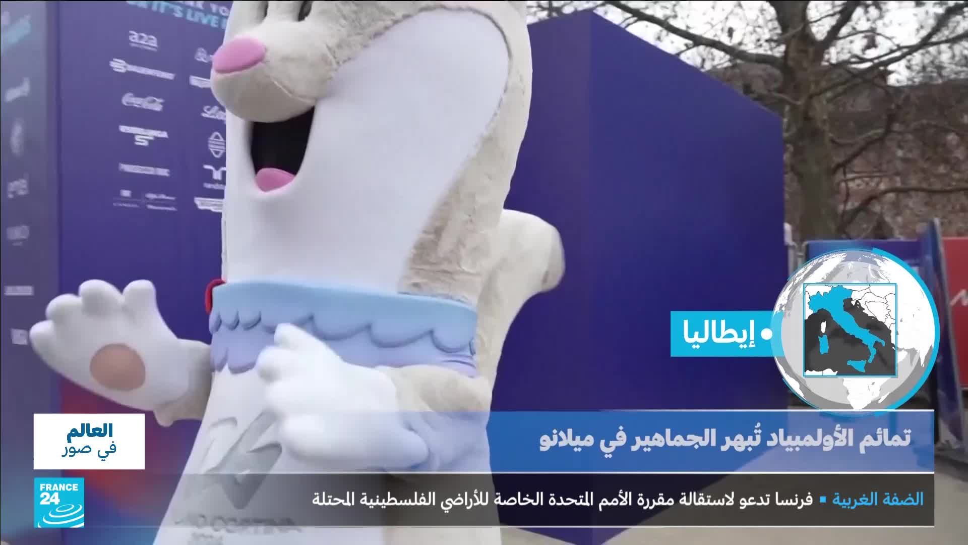 A large, white rabbit mascot with a blue collar waves its paws. Behind it, a blue banner displays text in Arabic, including "France 24" and "Italy."