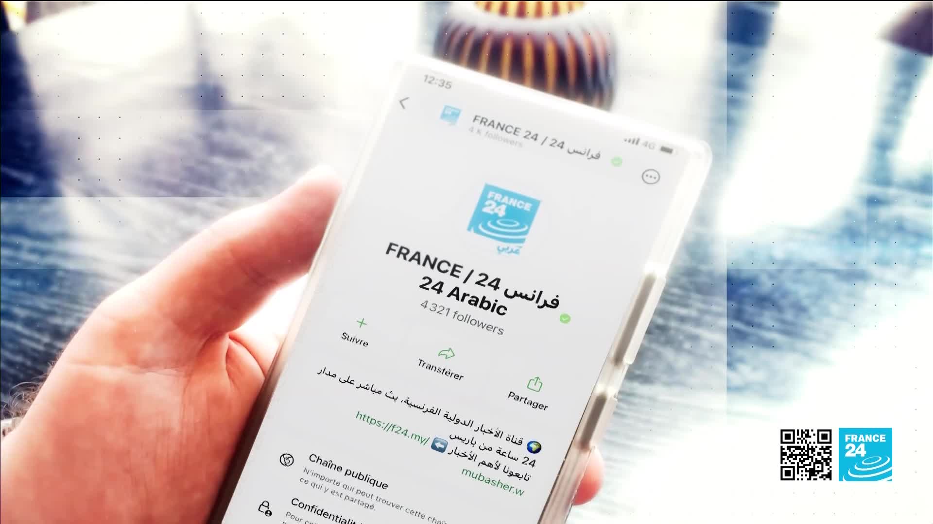 A thumb rests on the screen of a smartphone, displaying the FRANCE 24 Arabic profile. The phone shows the channel's logo and follower count, along with options to subscribe and share.