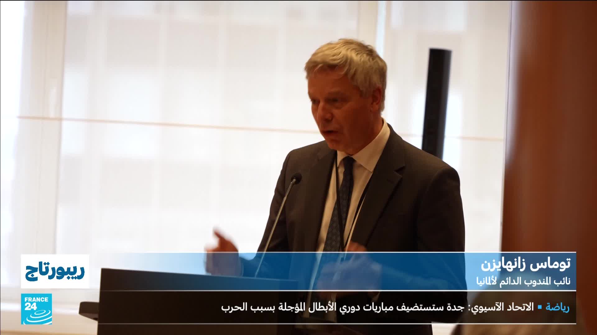 A man in a suit speaks at a podium, gesturing with his left hand. The France 24 logo appears in the lower left corner. A man in a suit speaks at a podium, gesturing with his left hand. The France 24 logo appears in the lower left corner.