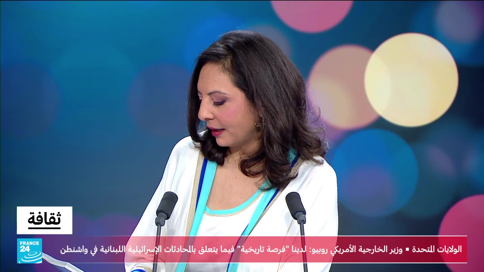 A woman in a white jacket stands at a podium, speaking into a microphone. The France 24 logo is visible in the lower left corner.
