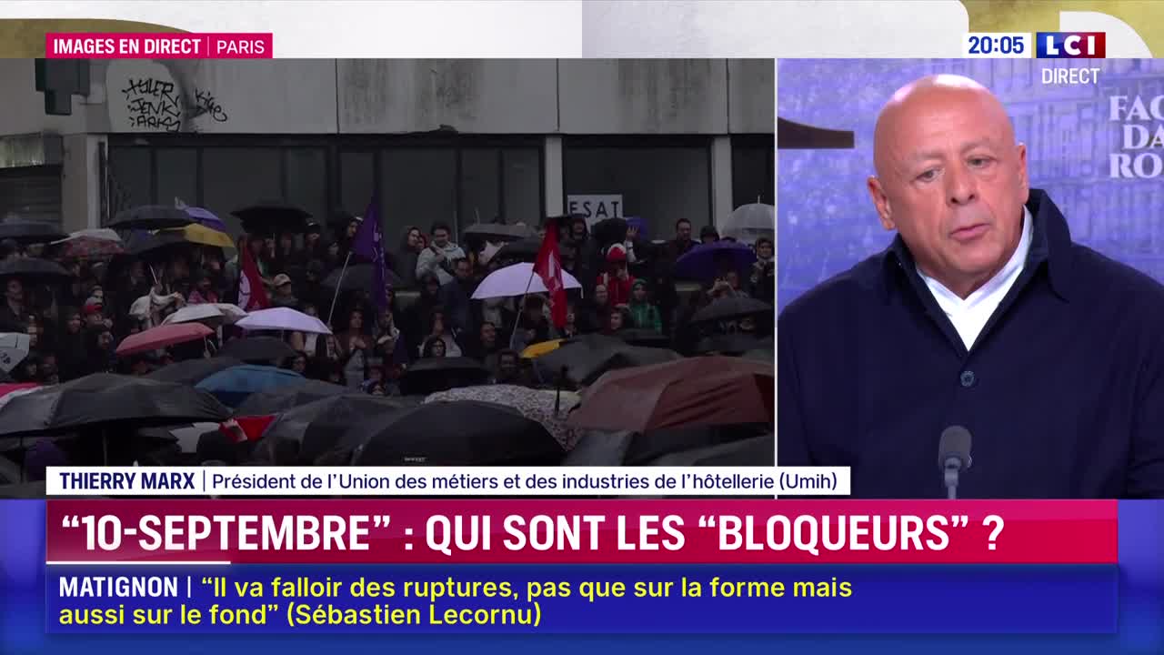 Outside, a crowd huddles under umbrellas, some holding flags, in front of a building. Across the screen, a man on LCI is speaking, the focus of the broadcast.
