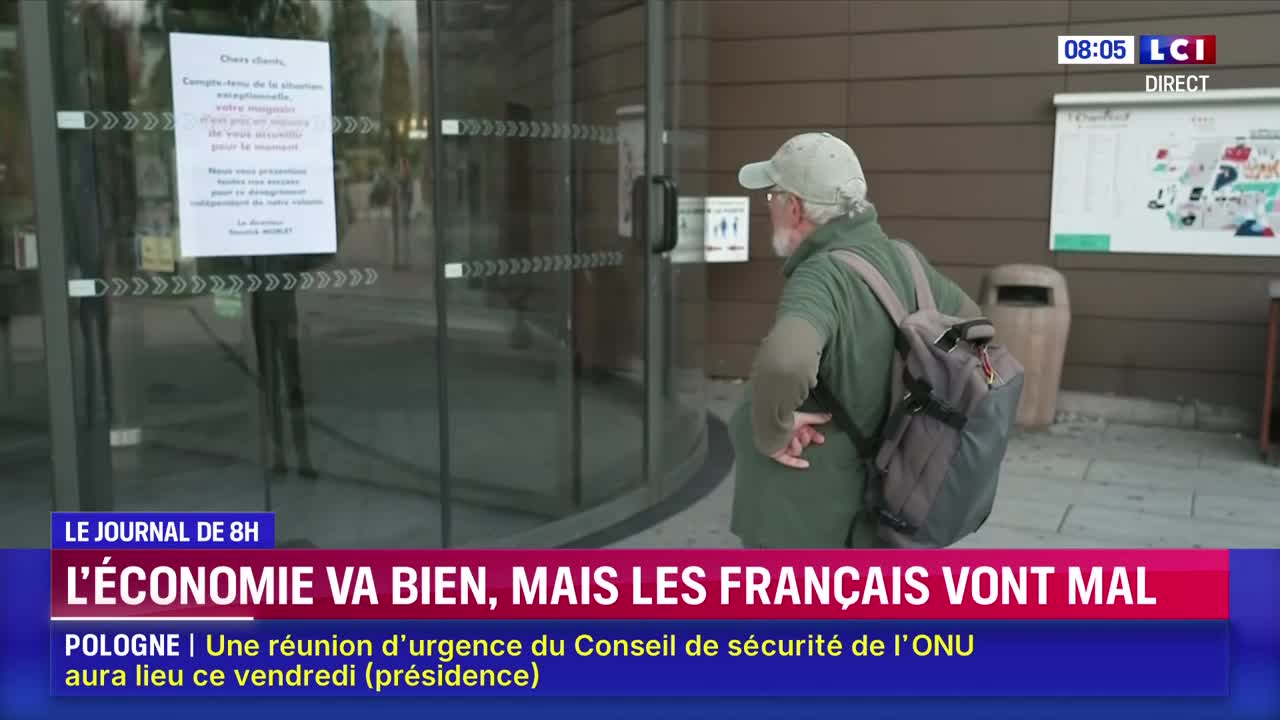 An older man, wearing a cap and carrying a backpack, is about to enter a revolving door. A sign posted on the glass door is visible, and the LCI news logo is in the corner.
