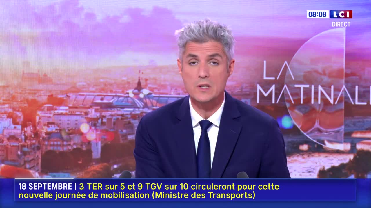 A man in a dark suit is speaking directly to the camera, his silver hair neatly styled. Behind him, a cityscape fades into a soft, early morning light, and the LCI logo is visible in the corner.
