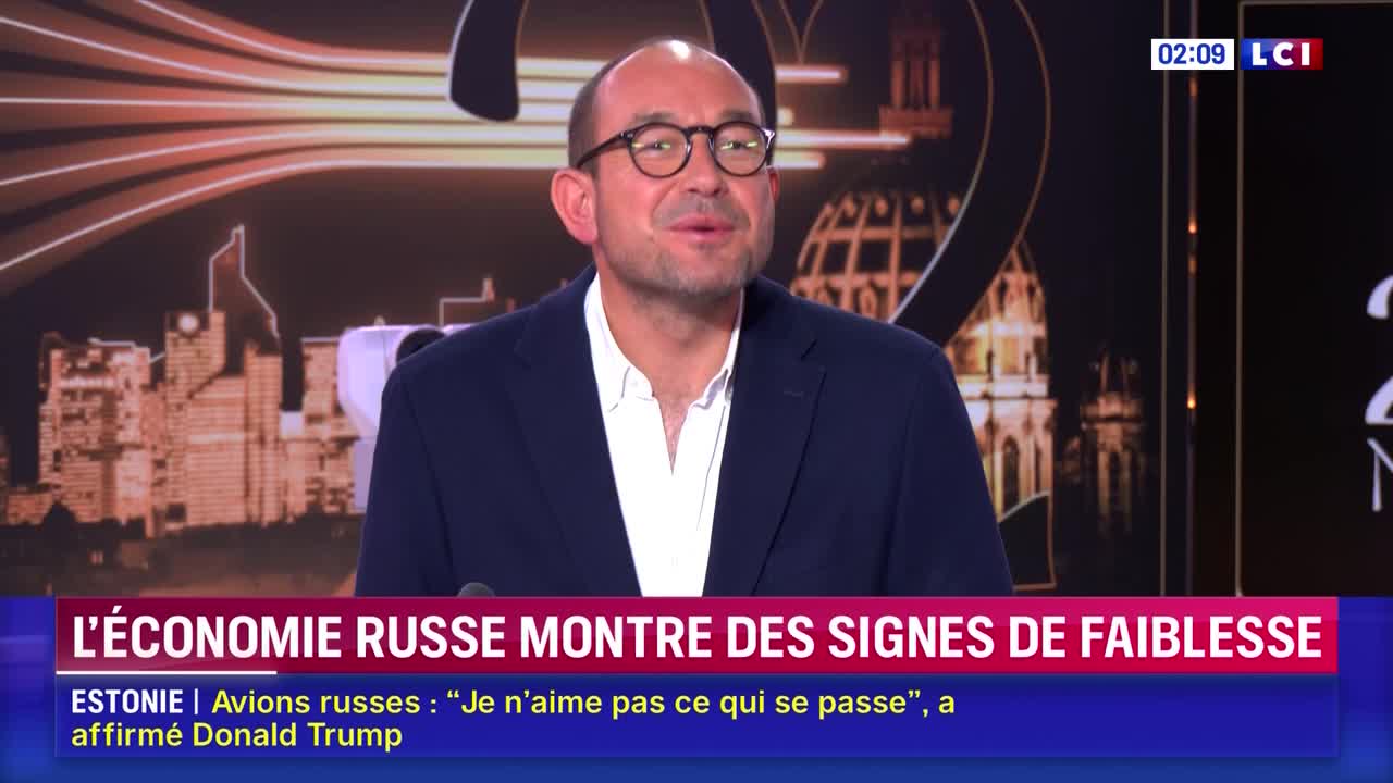 A man in glasses and a blazer is speaking, his mouth moving as he addresses the camera. The LCI logo and a headline about the Russian economy are displayed on the screen behind him.
