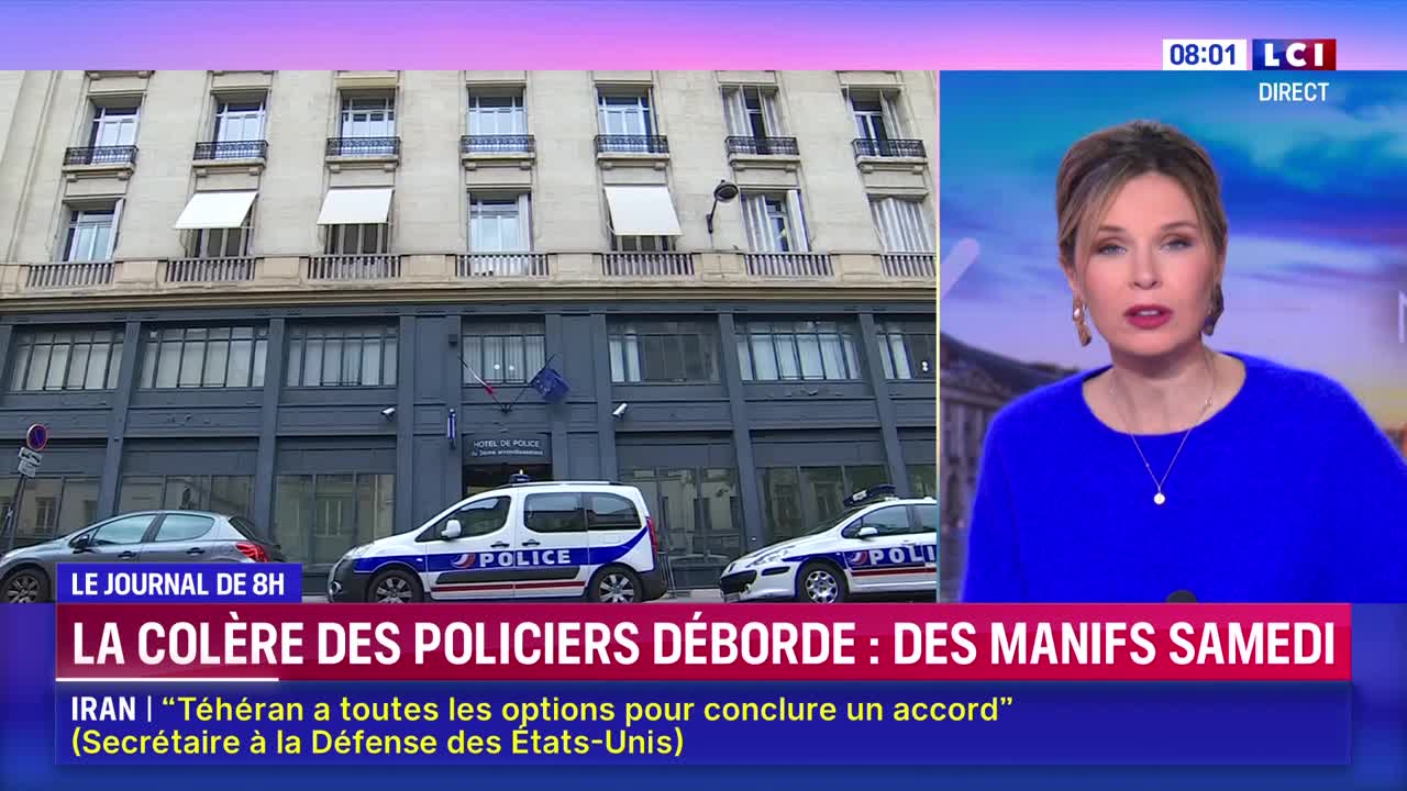 Two French police cars are parked in front of a building. A woman in a blue sweater is speaking on LCI.
