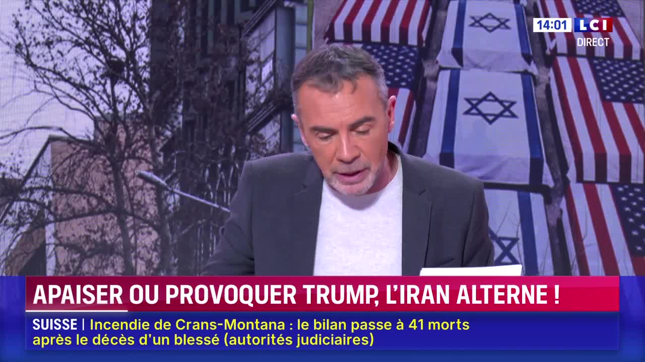 A man in a dark jacket speaks on LCI, a French news channel. Behind him, rows of coffins draped in American and Israeli flags are stacked.