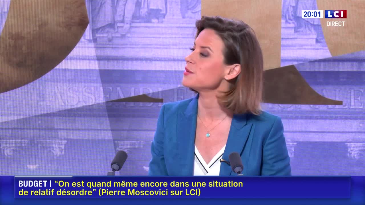A woman in a blue blazer speaks into a microphone, her gaze directed just off-camera. Behind her, a graphic displays "ASSEMBLÉE" in large letters.