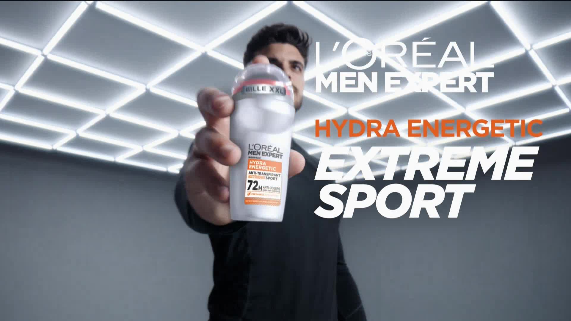 A man, seen from the chest up, holds out a white and orange deodorant can. The product's name, "Hydra Energetic Extreme Sport," is boldly displayed alongside the L'Oréal Men Expert logo.
