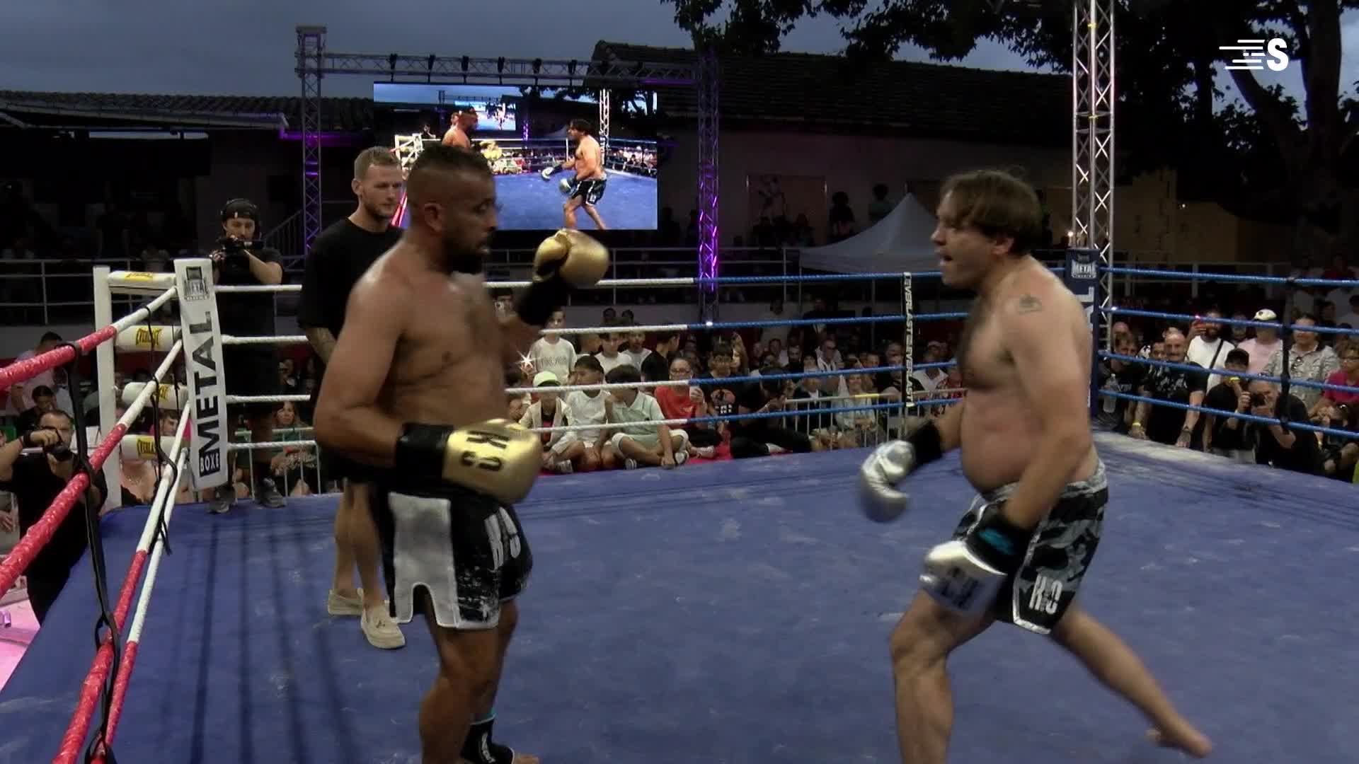 In a boxing ring, two men are facing off, gloves raised. One, in gold and black, looks ready to strike as his opponent moves to the side.

